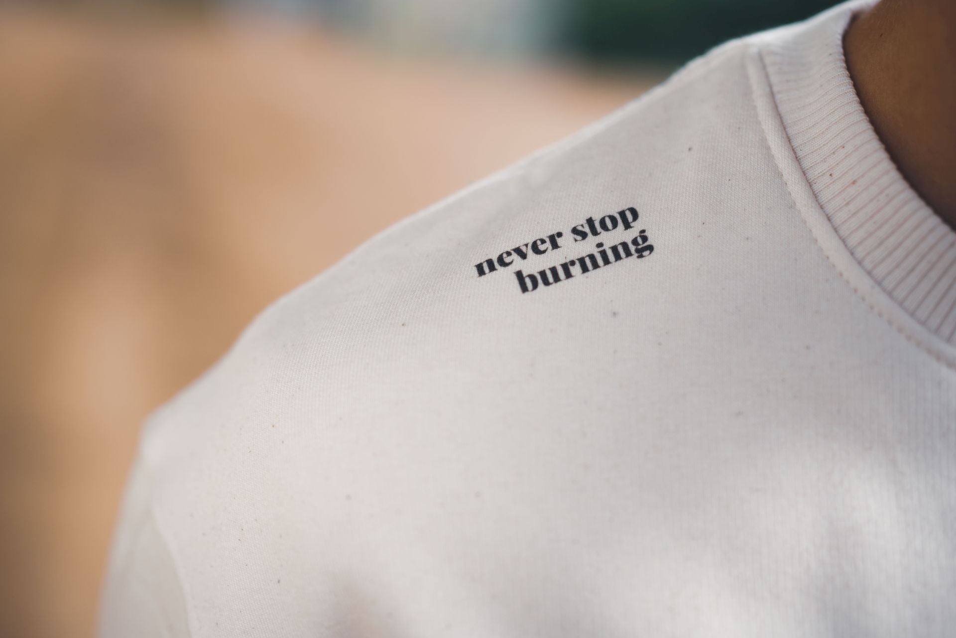 Oversized Sweatshirt aus 100% Bio-Baumwolle mit kraftvollem „Never Stop Burning“-Zitat
